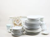 a lot of white plates and cups on the table