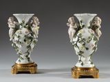 paire de vases anciens en porcelaine, ornés d'anges et de fleurs, sur des socles dorés