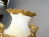 un grand vase blanc orné d'un motif doré