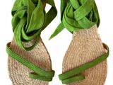 pair of women ' s sandals with a green ribbon tied to them