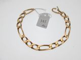 un gros plan sur un bracelet en chaîne dorée muni d'une étiquette de prix