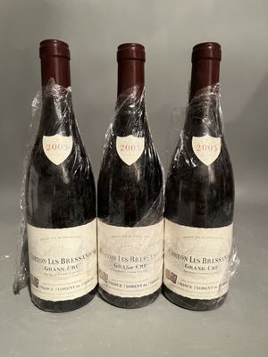 three bottles of wine wrapped in plastic sitting on top of a table