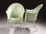 two green chairs sitting next to each other on a white floor