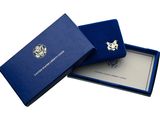 a blue gift box with a silver medal in it