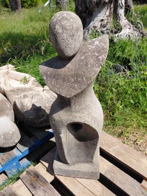 une statue en pierre posée sur un banc en bois