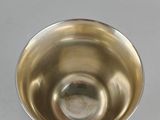 a silver cup sitting on top of a silver plate