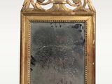 a mirror with a gold frame and a bird on it