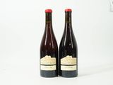 deux bouteilles de vin posées l'une à côté de l'autre sur une surface blanche
