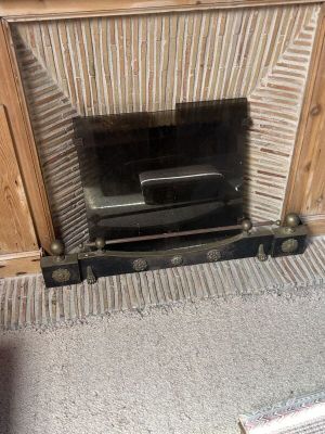 a fire place in the corner of a room with a television on it