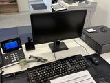 a desk with a computer, printer, telephone, and other items on it