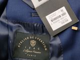 the label of a blue suit is on the back of a jacket