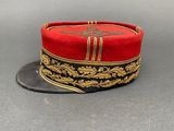 an image of a red hat with gold trims on a gray surface