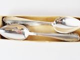 three spoons in a box on a white surface