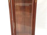 une vitrine ancienne en bois surmontée d'une porte vitrée