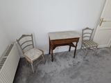 une petite table et deux chaises dans une petite pièce