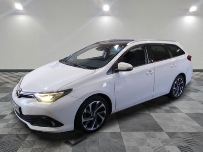 a white toyota auris parked on a checkered tile floor