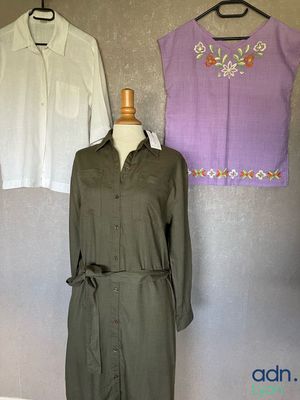 three women ' s dresses hanging on a wall in front of a mirror