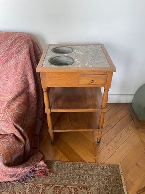 une petite table sur laquelle se trouve un bol, à côté d'un canapé