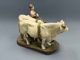 statue of a man on a cow with a man on a cart