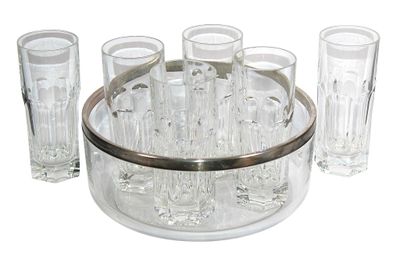 des bouteilles et des verres sont disposés en cercle sur une surface blanche