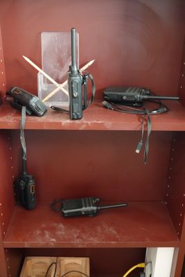une bibliothèque rouge sur laquelle sont posées deux radios