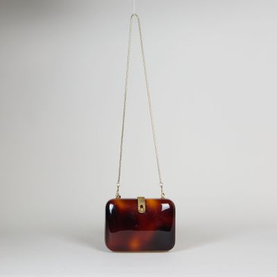 un sac à main marron en écaille de tortue suspendu à une chaîne