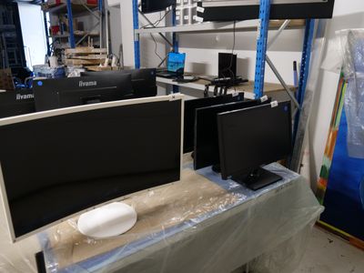 two monitors sitting on a table in the middle of a room