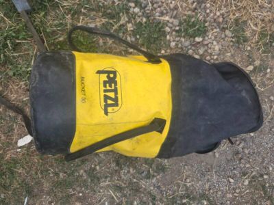 un sac de voyage jaune et noir posé par terre