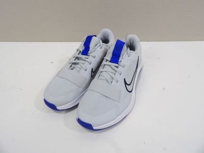 une paire de baskets blanches et bleues posées sur une surface blanche