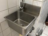 un évier en acier inoxydable dans le coin d'une salle de bains