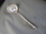 a silver spoon with a spoon handle on a table