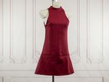 the red dress is on a mannequin stand in front of a white wall