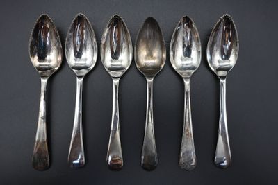 six spoons are lined up in a row on a black surface