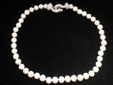 un collier de perles blanches sur fond noir