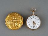 une montre de poche en or et une pièce d'or posées sur une table
