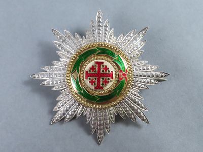 an image of a silver and green broochle with a cross on it