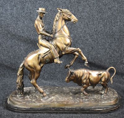 statue of a man on a horse with a bull in the foreground
