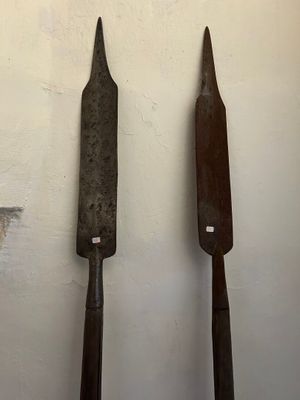 Deux vieux outils sont posés sur une table près d'un mur.