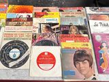 une table sur laquelle sont posés de nombreux disques et CD