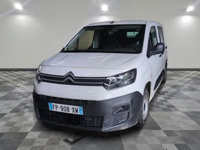 la camionnette blanche est garée sur un sol en damier dans le garage