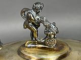 a silver plate with a figurine on top of it