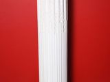 a white column with a red wall in the background
