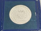 a silver coin in a blue box on a table