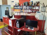 un bureau avec deux ordinateurs et un ventilateur dans un coin