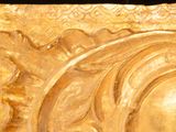 a gold plate with a picture of a sun on it