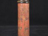 an old metal canister with red paint on it