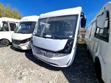 de nombreux bus blancs garés les uns à côté des autres sur un parking