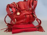 le sac à main rouge est posé sur un tissu rouge