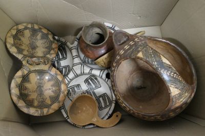 une boîte en carton remplie de nombreuses pièces de poterie de toutes sortes