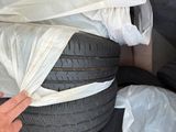 a person reaching for a tire that has been wrapped in plastic